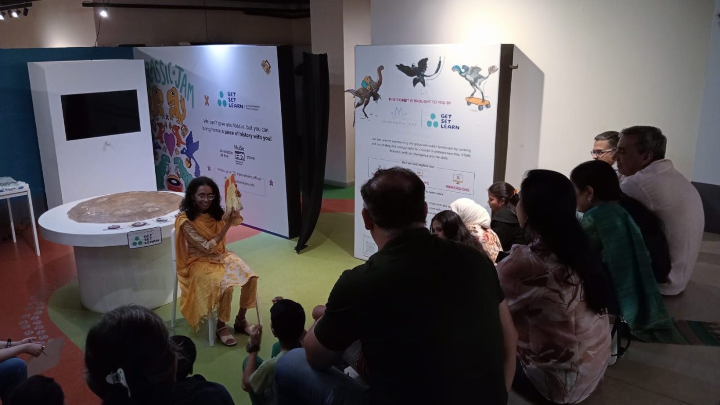 A storyteller reading to families seated on the exhibition floor