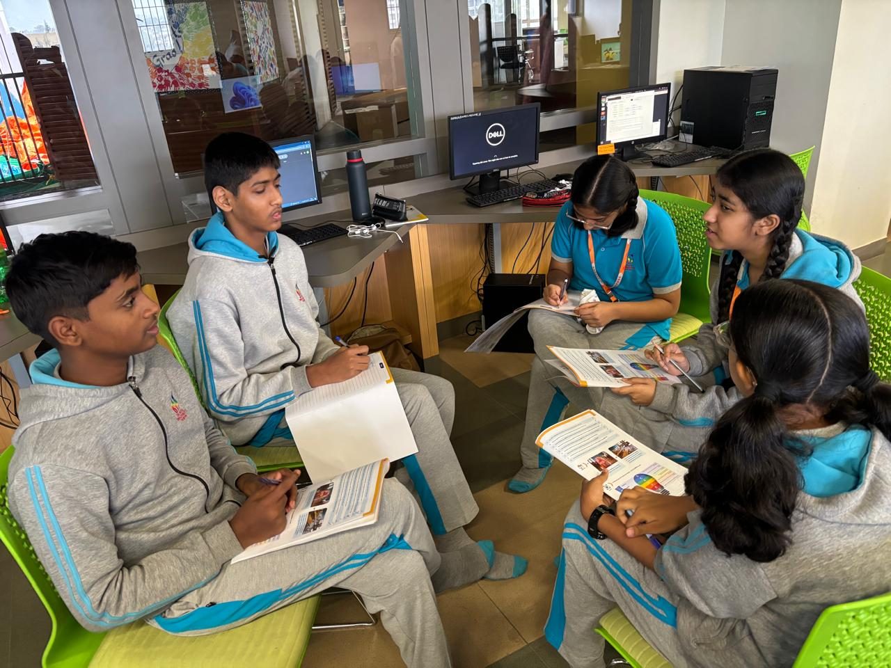 Students working through a live case in a circle, papers on their laps