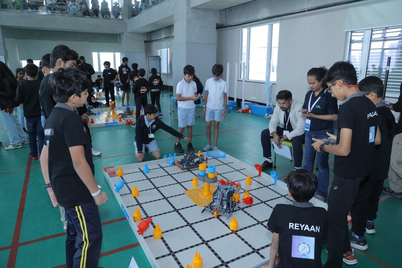 Teams and volunteers around two VEX IQ fields on the competition floor