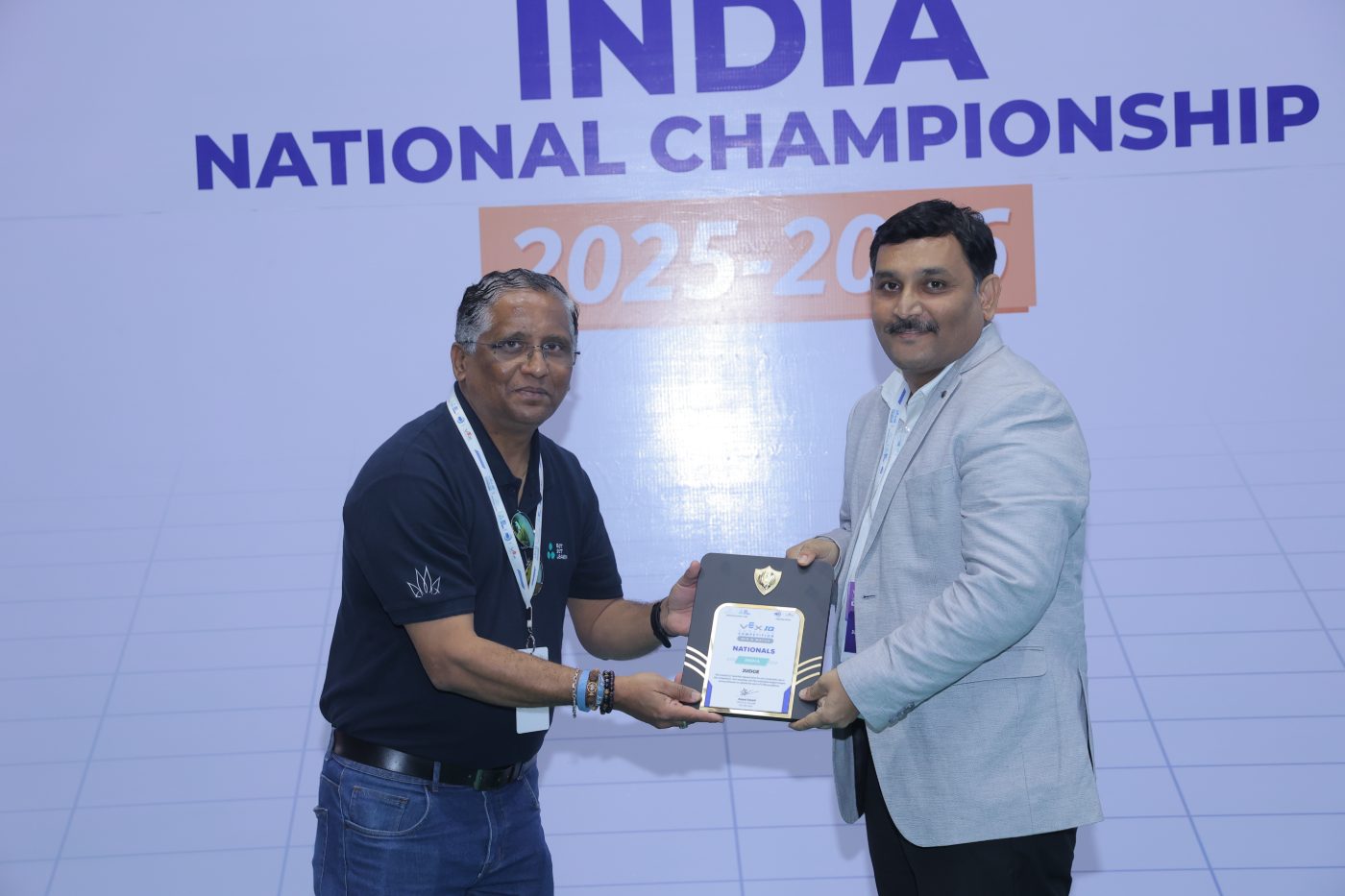 A judge receiving a National Championship plaque from a Get Set Learn team member