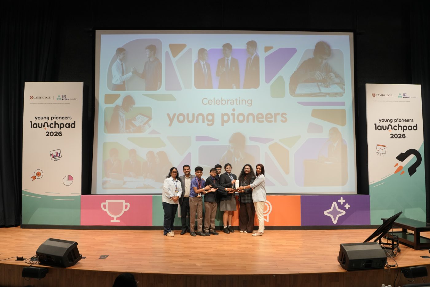A winning team on stage with their school mentors and the Get Set Learn team