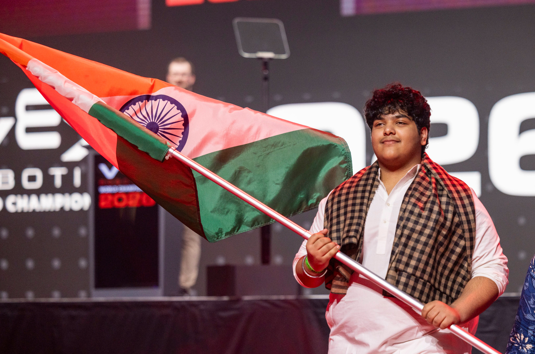 A student carrying the Indian flag across the main stage
