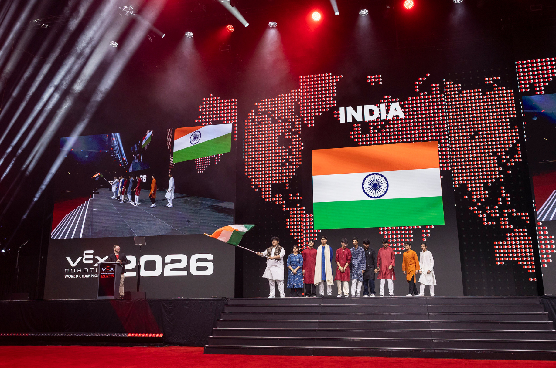 Team India on stage at the VEX Robotics World Championship 2026, with the Indian flag on the arena screen