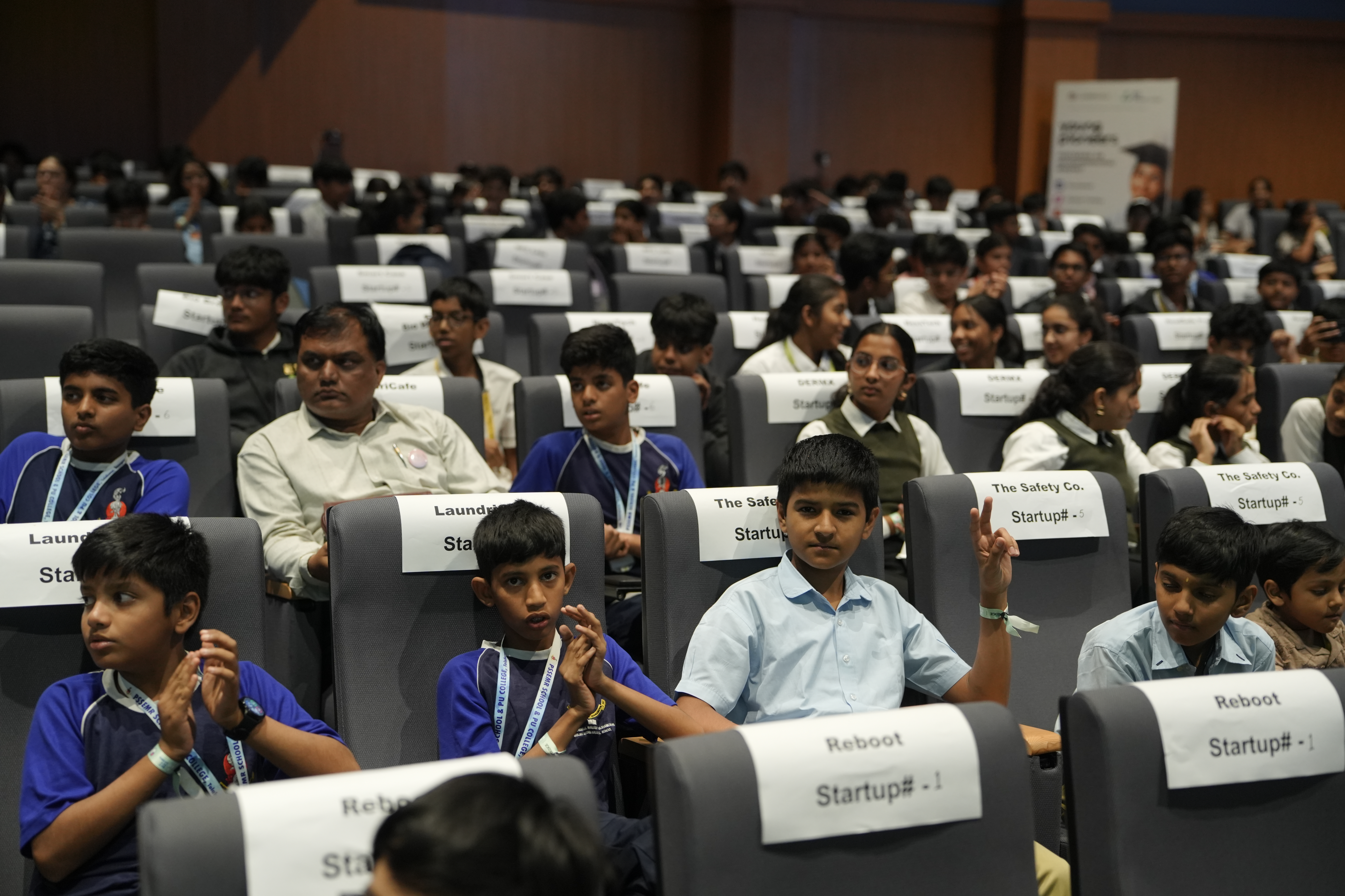 Students in the audience raising hands during the jury question round