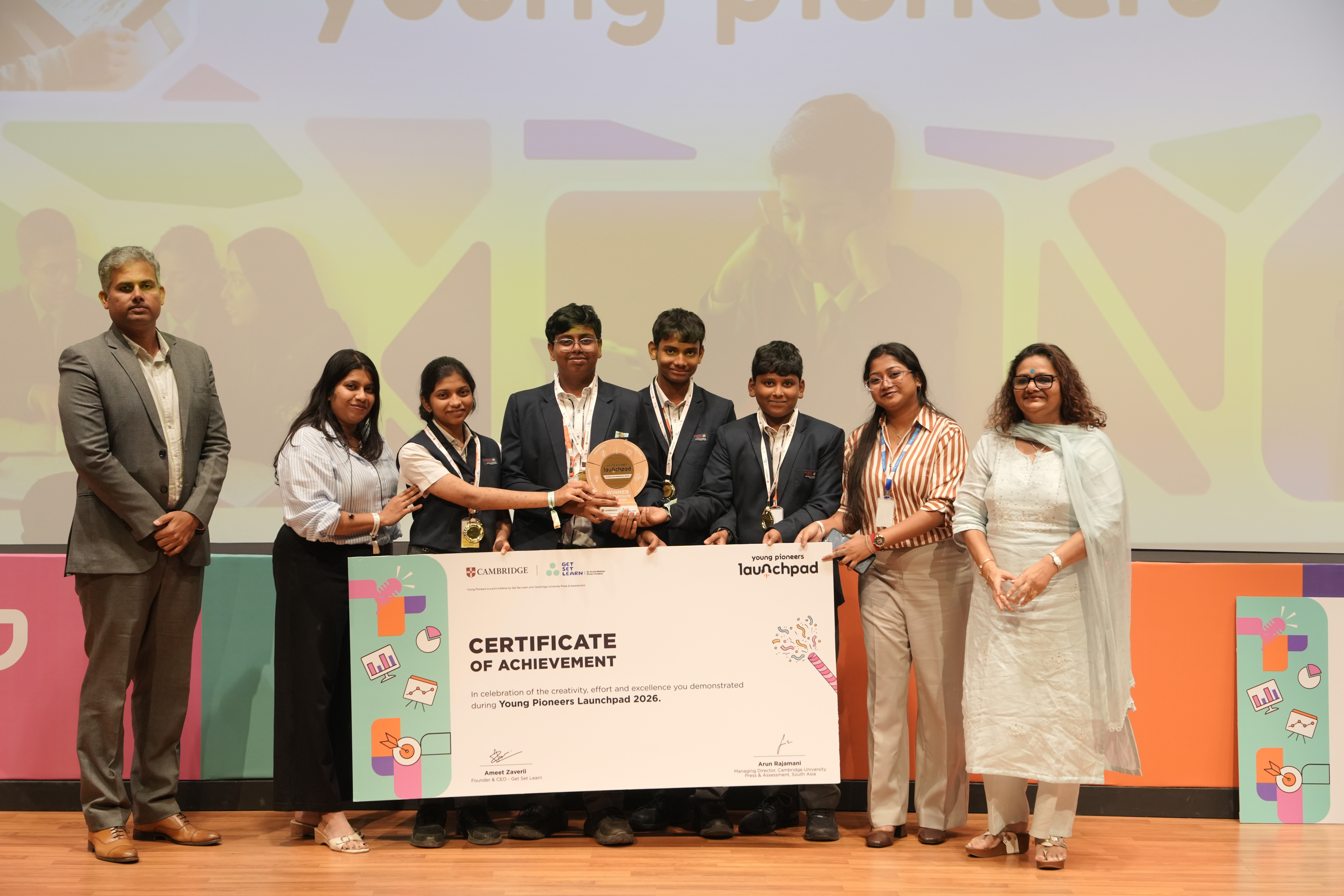 The Steel Root team from Laurel High Global School on stage with their trophy and certificate
